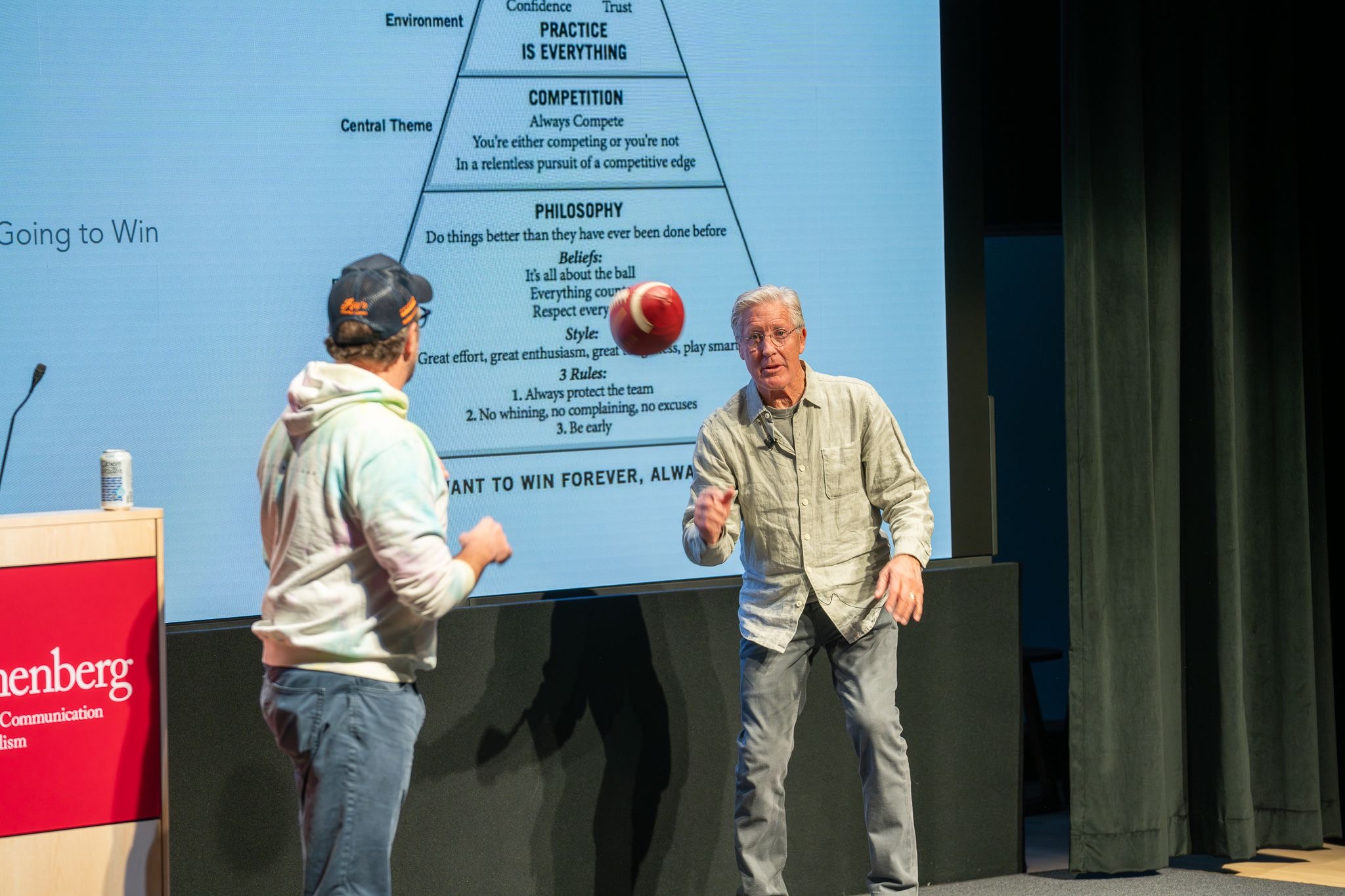 Close three-shot of David Belasco, Jason Sudeikis, and Pete Carroll on stage